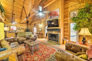 a living room with leather furniture and a fireplace at Quiet Cabin Retreat on 30 Acres Near Kentucky Lake in New Concord