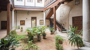 Un patio interior con plantas en macetas en un edificio. en El Patio del Arrayán - Apartamentos Aloha Toledo, en Toledo