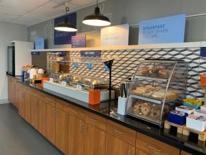 a bakery counter with a display of bread and pastries at Holiday Inn Express and Suites Pittsburgh West Mifflin, an IHG Hotel in West Mifflin