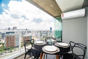 comedor con mesa y sillas y ventana grande en River One 2303 - Luxury Studio, en São Paulo