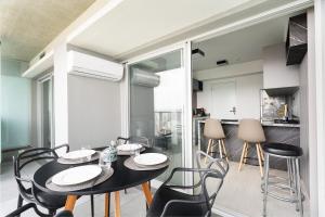 comedor y cocina con mesa y sillas en River One 2303 - Luxury Studio, en São Paulo