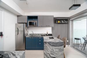 cocina con armarios azules y nevera de acero inoxidable en River One 2303 - Luxury Studio, en São Paulo
