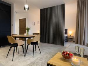 a living room with a table and chairs at URBAN APARTMENTS PREMIUM DOWNTOWN Opolska 10 No 90 with 2 GARAGES in Katowice