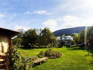 a yard with benches and a house in the background at Lavanda cottage in Verkhovyna