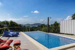 a swimming pool with chaise lounge chairs and a swimming pool at Villa primor Chaloklum Koh phangan in Chaloklum