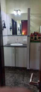 La salle de bains est pourvue d'un lavabo et d'un miroir. dans l'établissement Arenas Calidas, à Las Grutas