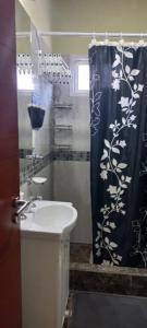 a bathroom with a sink and a shower curtain at Arenas Calidas in Las Grutas
