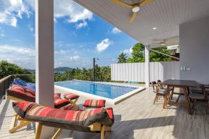 a patio with a pool and a table and chairs at Villa primor Chaloklum Koh phangan in Chaloklum