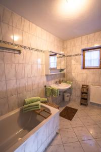 a bathroom with a bath tub and a sink at Chalet Obenland Panorama Aussicht Kitzbühler Alpen in Bramberg am Wildkogel