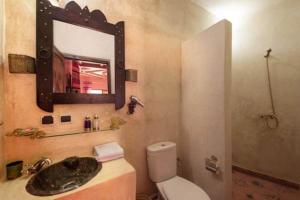 ein Badezimmer mit einem Waschbecken, einem WC und einem Spiegel in der Unterkunft Kasbah Imlil in Imlil