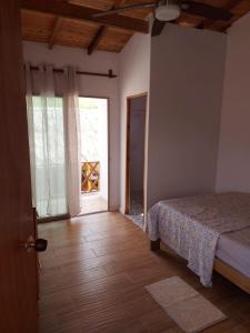 a bedroom with a bed and a door to a window at La Casa de Tita _ Usiacuri in Usiacurí