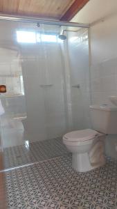 a white bathroom with a toilet and a shower at La Casa de Tita _ Usiacuri in Usiacurí