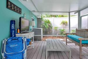 a living room with a couch and a tv at Charming Studio w Pool One Mile to Beach Pets Welcome in Lake Worth
