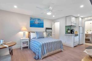 a bedroom with a bed and a table and a kitchen at Charming Studio w Pool One Mile to Beach Pets Welcome in Lake Worth