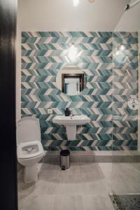 a bathroom with a sink and a toilet and a mirror at Pensiunea Magnesia (4 margarete****) in Sânâteşti