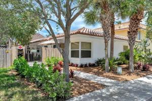 a house with palm trees in a yard at Spacious 1BR APT Half Mile to Beach Pets Welcome in Lake Worth