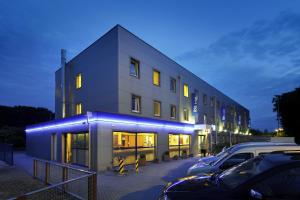 a building with cars parked in a parking lot at ibis budget Aachen Raeren Grenze in Raeren