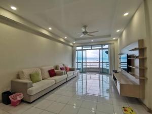 a living room with a couch and a television at Ocean Palms in Melaka