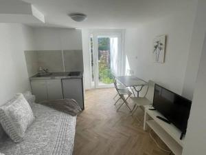 - un salon avec un canapé, une télévision et une table dans l'établissement Appart cosy avec terrasse, à Mons-en-Baroeul