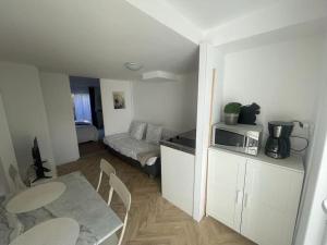 ein Wohnzimmer mit einem Tisch und einer Mikrowelle in der Unterkunft Appart cosy avec terrasse in Mons-en-Baroeul