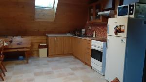 uma cozinha com um frigorífico branco e uma mesa em Chalupa Naty Zdíkov em Zdíkov