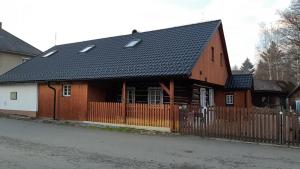a brown house with a black roof and a fence at Chalupa Naty Zdíkov in Zdíkov