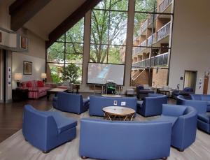 a large room with blue chairs and a large screen at Fort Magruder Historic Williamsburg, Trademark by Wyndham in Williamsburg