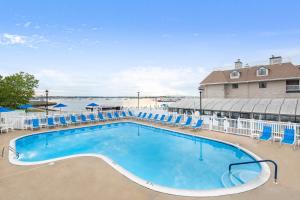 une grande piscine avec des chaises bleues et un bâtiment dans l'établissement Wellington Resort, à Newport