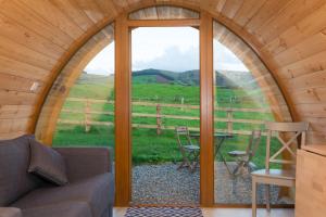 a room with a couch and a table and a window at Kilbane Glamping in Kilbane