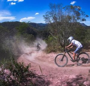 2 personnes à vélo sur un chemin de terre dans l'établissement Pouso Donana Cama e Café, à Itaipava