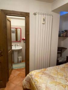 ein Schlafzimmer mit einem Bett und ein Badezimmer mit einem Waschbecken in der Unterkunft Casa Felicia in Pescasseroli