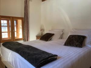 a bedroom with a large white bed with two pillows at Inspiration Montagne Chambre d'hôtes in Névache