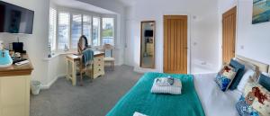 1 dormitorio con cama, escritorio y lavamanos en Avon Beach Bed & Breakfast, en Christchurch