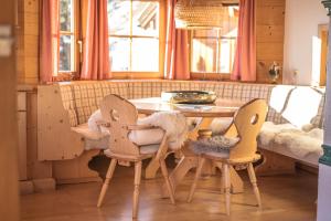 een keuken met een houten tafel en 2 stoelen bij Chalet Obenland Panorama Aussicht Kitzbühler Alpen in Bramberg am Wildkogel