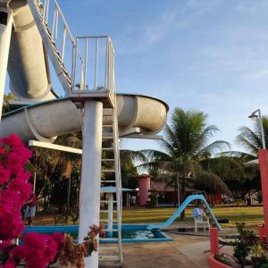 a water slide in a park with a slide at Camping e Pousada Buritis Park 