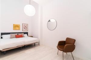 Acogedor y Comodo apartamento Madrid A/C في مدريد: غرفة نوم بسرير وكرسي