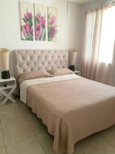 um quarto com uma cama grande e uma colcha branca em Apartamento vacacional - disfruta playa y toboganes a 32km de la ciudad em ArraijÃ¡n