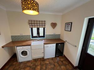 a laundry room with a washer and dryer at 4 Bed Farmhouse - Pets - Garden - Parking in Beaumaris