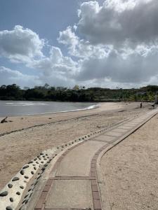 a walkway on a beach next to the water at Apartamento vacacional - disfruta playa y toboganes a 32km de la ciudad in ArraijÃ¡n
