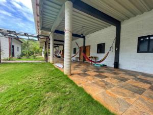 a covered patio with a grass yard and pipes at RodMar Hotel in El Cuco