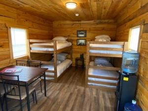 a cabin with four bunk beds and a table at Canal Cabins in Paw Paw