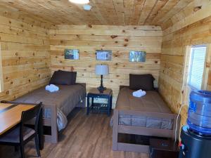 a room with two beds in a log cabin at Canal Cabins in Paw Paw