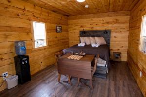 a bedroom with a bed and a table in a cabin at Canal Cabins in Paw Paw