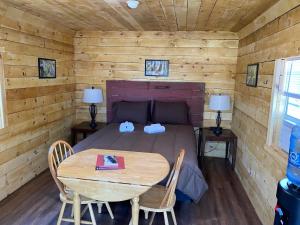 a bedroom with a table and a bed in a cabin at Canal Cabins in Paw Paw