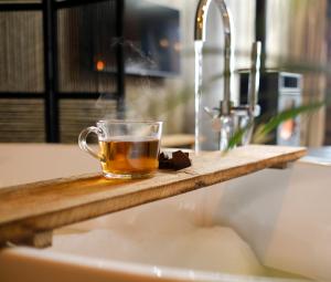 a cup of tea sitting on a counter next to a sink at Landgoed Lodges Scholten Linde in Rossum