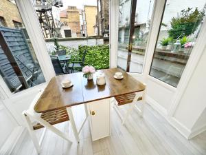 a table on a balcony with flowers on it at LUXURIOUS Terrace 2 Bedrooms in Relaxing Covent Garden Apartment in London