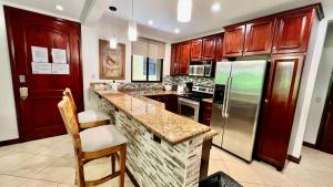a kitchen with wooden cabinets and a granite counter top at Monte Carlo Luxury Condominiums in Jacó
