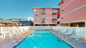 una piscina con sillas y un edificio en Sands II 1-J, en Carolina Beach