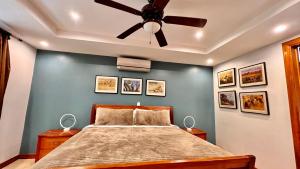 a bedroom with a bed with a ceiling fan at Monte Carlo Luxury Condominiums in Jacó