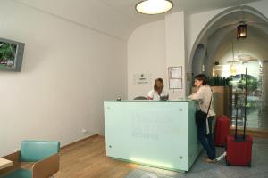 two women standing at a counter with their luggage at Hotel v Centru in České Budějovice